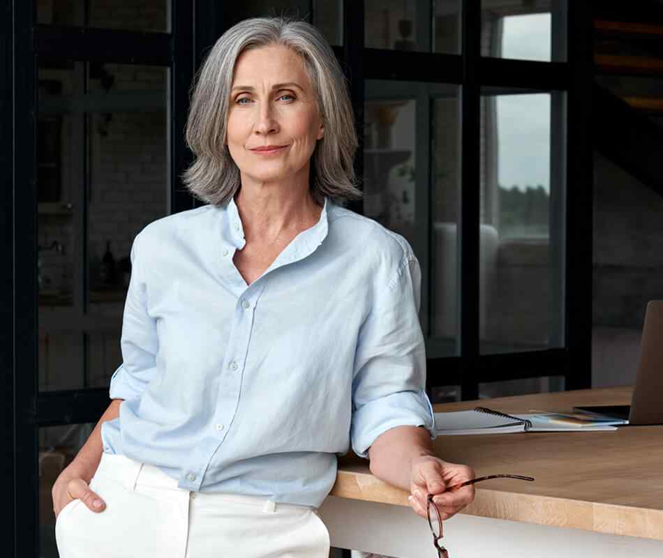 Confident,Stylish,European,Mature,Middle,Aged,Woman,Standing,At,Workplace. Confident stylish european mature middle aged woman standing at workplace. Stylish older senior businesswoman, 60s gray-haired lady executive leader manager looking at camera in office, portrait.